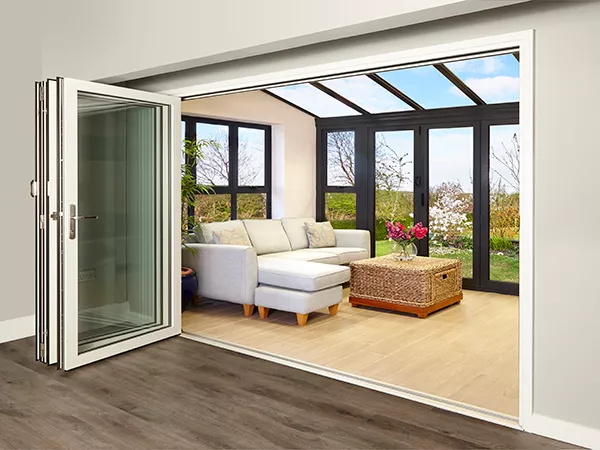 An opened bi-folding door leading into an extension